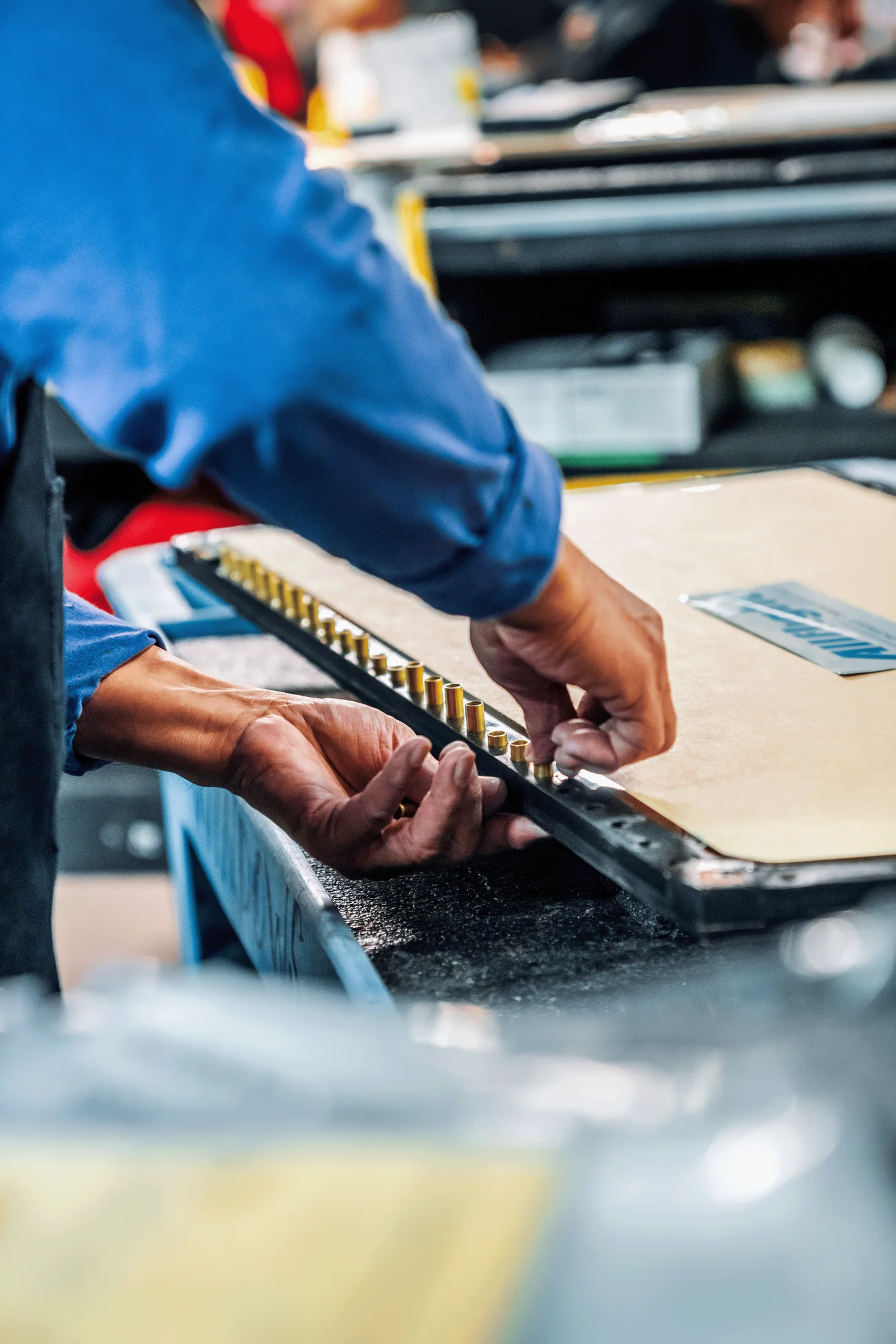 An Allflight technician working by hand on an aircraft component at a workbench
