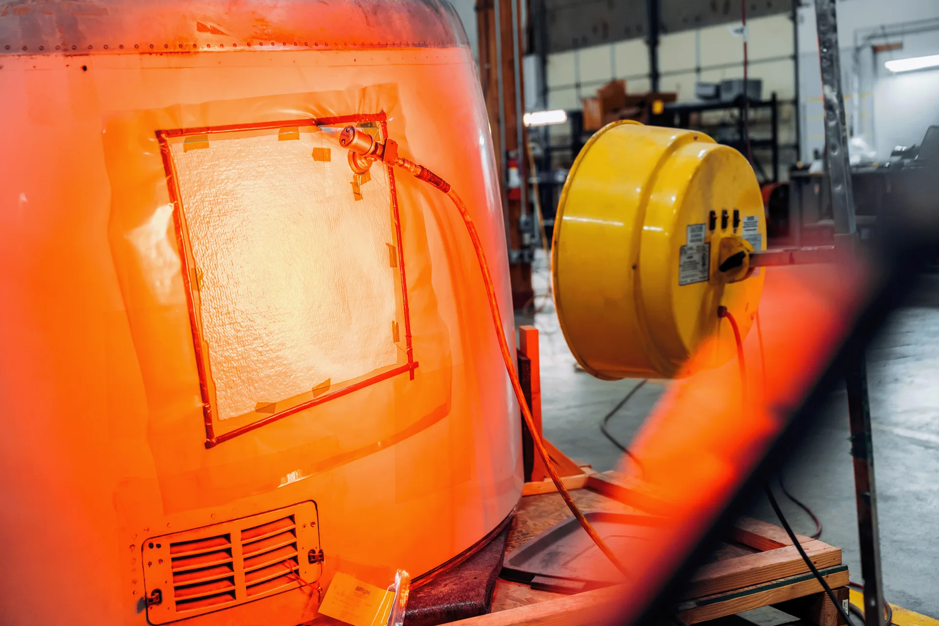 Aircraft structure with a repair patch beneath orange lamps