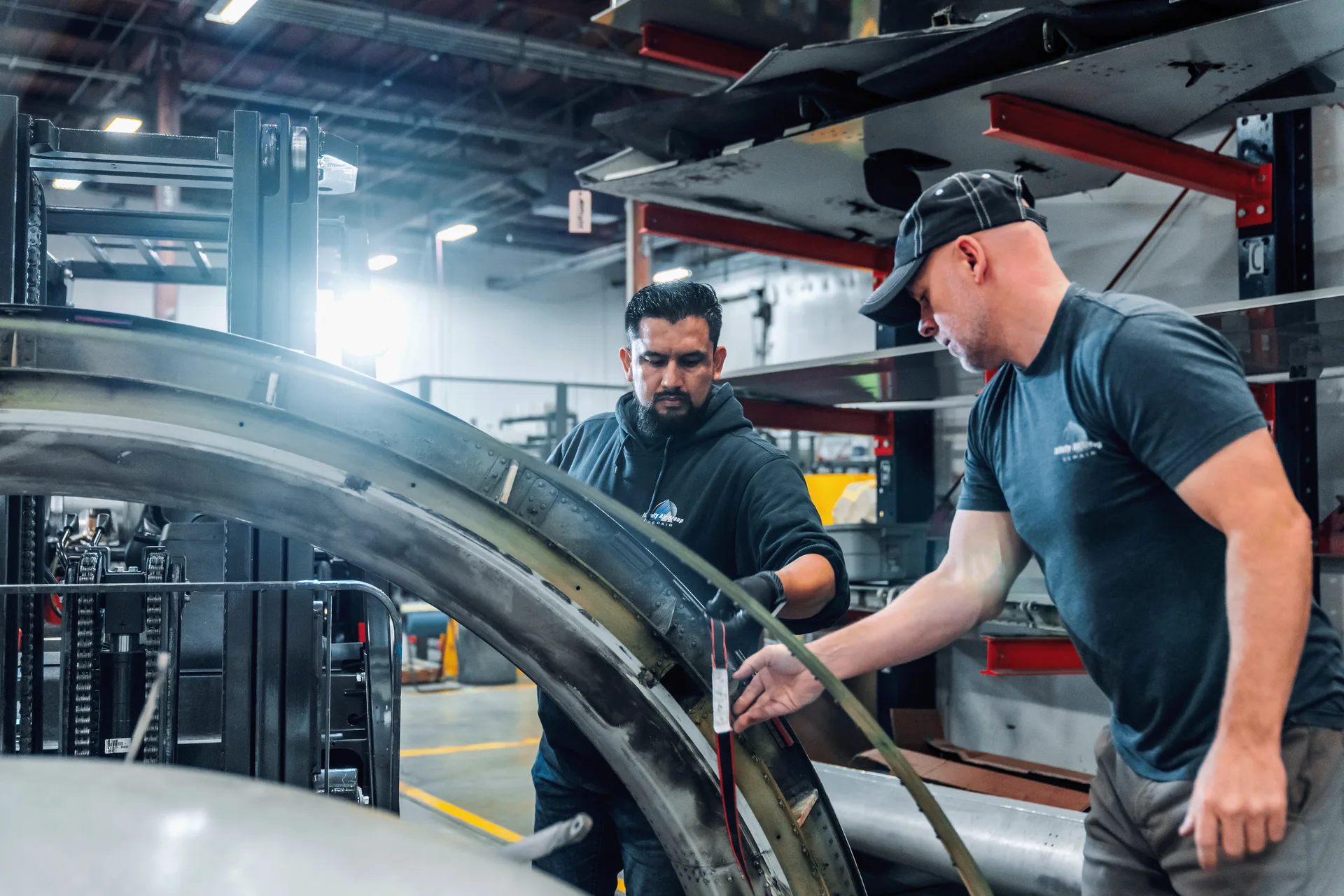 Two Allflight technicians inspecting a curved aircraft structure together